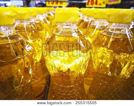 Food Concept. Many Bottles Of Palm Oil Are In The Tray For Sale In Supermarket. Selective Focus And 