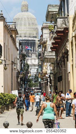 Havana, Cuba - 25 July 2018: People Going About Their Day In Havana Cuba With Cuban Flag And The Cap