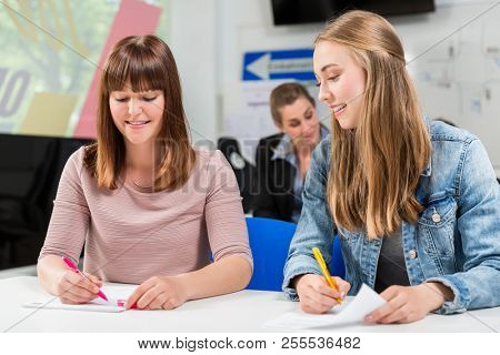 Students writing test or theoretical exam for license after finishing their driving lessons