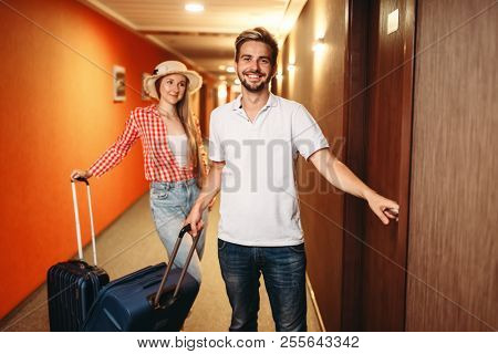 Couple with suitcases checking into the hotel