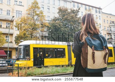 A Tourist Girl With A Backpack On Berlin Street Crosses The Road To The Trom Stop To Continue Her Jo