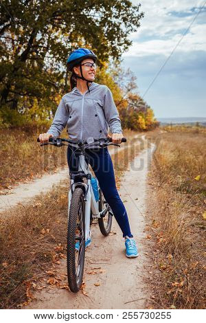 Young Woman Riding A Bicycle In Fall Field. Healthy Lifesyle
