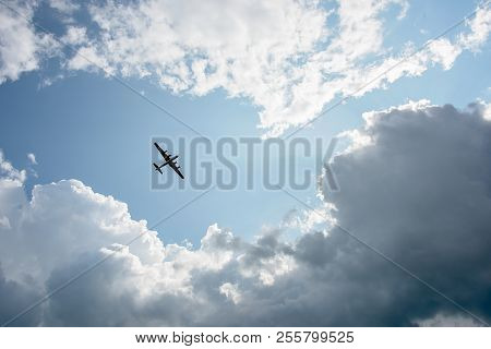 A Bomber From Wwii Flying Overhead Surrounded By Clouds