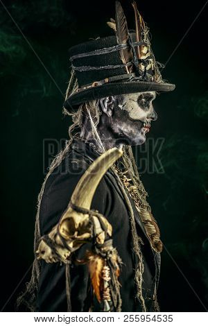 A man with a skull makeup dressed in a tail-coat and a top-hat. Baron Saturday. Baron Samedi. Dia de los muertos. Day of The Dead. Halloween.