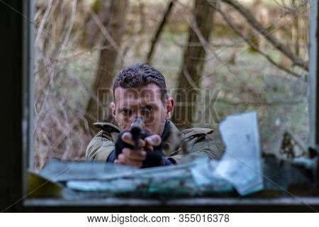 Soldier Pointing A Gun Trough A Broken Window With No Helmet