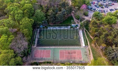 Aerial View Of A Soccer Game In A Park Stadium Next To A Tennis Court