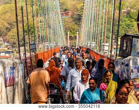 Rishikesh, India - Circa April 2018. Bridge Over Ganga River, Ram Jhula, Rishikesh. People Crossing 