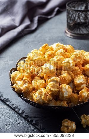 Popcorn In Caramel Glaze In A Plate On A Dark Concrete Table. Copy Space.