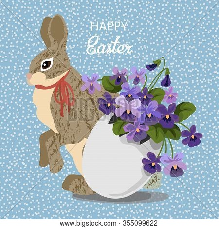 Cute Gray Rabbit With Flowers In Eggshell, Hare And Bouquet Of Lilac Violet In Egg On A Blue Backgro