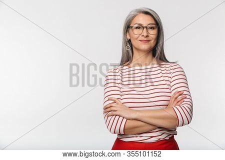 Image of adult mature woman with long gray hair wearing eyeglasses looking at camera isolated over white background