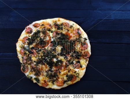 Pizza With Sausage And Tomatoes Lies On The Table
