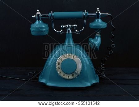 Old Telephone Stands On A Black Background