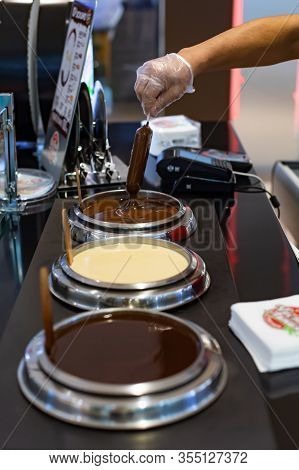 Moscow, Russia - January 6, 2020: Popsicle Ice-cream Is Dipped In Liquid Milk Chocolate. Ice Cream S