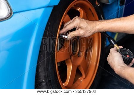 Hands Of Mechanic Man Checking Tire Air Pressure. Maintenance Car.