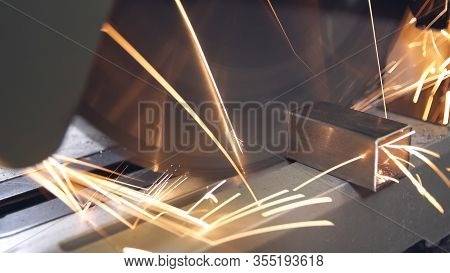 Metal Grinding Machine With Sparks. Worker Sawing Steel. Dangerous And Hard Work Concept.