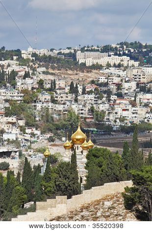 Magnificent gold domes of orthodox church in Jerusalem. Jerusalem on hills and the cloudy sky