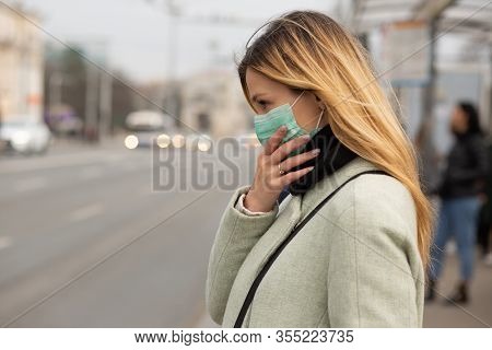 Sad Caucasian Woman Wearing Sterile Protective Medical Mask Ill By The Covid-2019 Corona Virus At Th