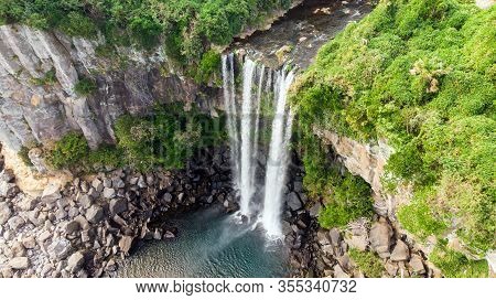 Aerial View Of The High Waterfall Jeongbang And Lagoon On Jeju Island, South Korea.