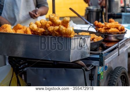 Chef Is Frying Chinese Deep Fried Dough In Hot Oil On Steel Pan. Youtiao, Padnoongo Or Fried Flour S
