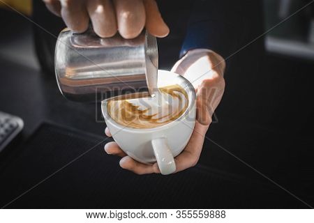 Closeup Image Of Male Hands Pouring Milk And Preparing Fresh Cappuccino, Coffee Artist And Preparati