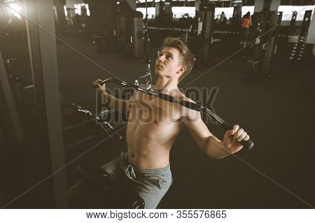 Handsome Power Athletic Man Training Pumping Up Back Muscles Pull Up In The Gym. Strong Bodybuilder 