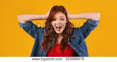 Omg. Excited Girl Shouting In Excitement Touching Head Looling At Camera Posing Over Yellow Backgrou
