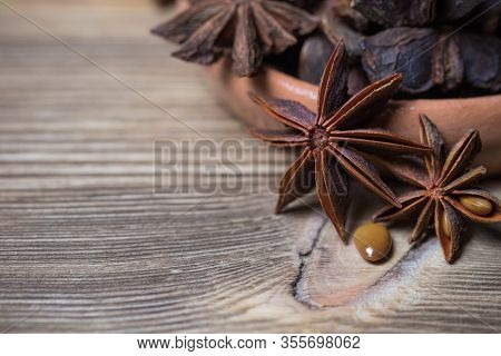 Star Anise With And Without Seed, Closed, In A Clay Plate On A Light Wooden Surface. Spice For The R