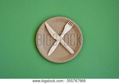 Eco- Friendly Tableware For Food And Wooden Eco-knife, Fork, Spoon On A Green Background With A Copy