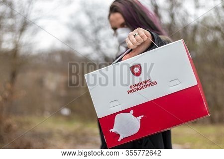 Young Woman Wearing A Protection Face Mask, Holding A Pandemic Preparedness Box Kit