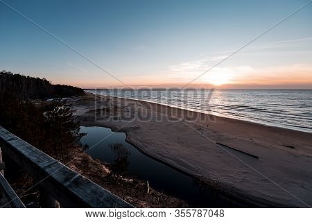 Sunset At Saulkrasti White Dune. View From Wooden Walkpath Over Sea, Small River And Sky