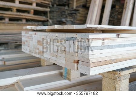 Pile Of Pine Wood In A Warehouse Or Storage Room. Wood Proceesing, Wood For Furniture