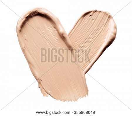 Foundation smear close-up. Foundation face make-up smudge, smears. Cosmetic liquid bb cream beige color heart shaped stroke. Make up texture, concealer isolated on white background. Love cosmetics