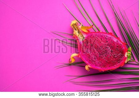 Half Of Fresh Ripe Dragon Fruit And Green Tropical Leaf Isolated On Pink Background With Copy Space 