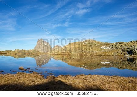 Midi Dossau Peak reflected in a lake. Ossau Valley, Pyrenees National Park, Pyrenees, France.