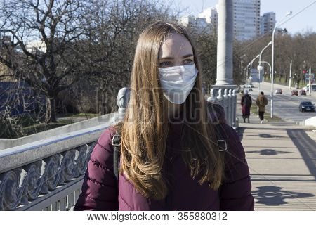 Beautiful Girl Student In A Medical Mask On A City Street