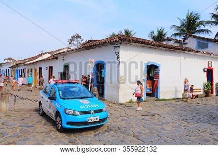 Paraty, Brazil - October 14, 2014: People Walk By Police Car In Old Town Of Paraty (state Of Rio De 