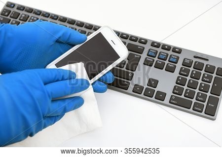 Disinfection In Public Places, The Fight Against The Virus, Coronavirus. A Working Hand Rubs A Mobil