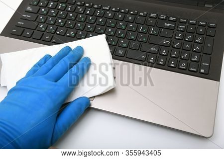 Disinfection In Public Places, The Fight Against The Virus, Coronavirus. A Working Hand Wipes A Lapt