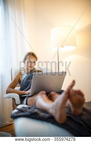 Pretty, young woman working from home during a pandemic coronavirus crisis
