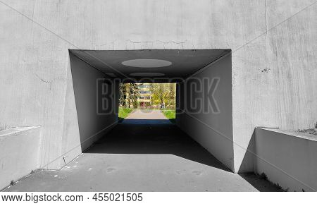 Empty Gray Underpass Going Into The Green And Sunny Park. The Underpass Is Dark Inside.