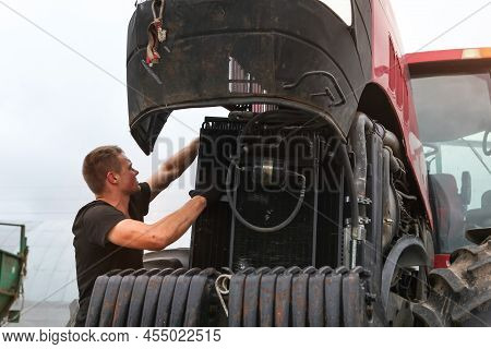 Belarus, Vitebsk, July 31, 2020. Farmer Mechanic Repairs Tractor Engine. Agricultural Machinery Repa