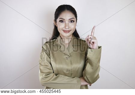 Smiling Beautiful Asian Woman Pointing Finger Upward To Empty Space In Studio White Isolated Backgro