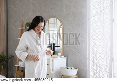 Beautiful Young Woman Wearing Soft White Robe In Bathroom