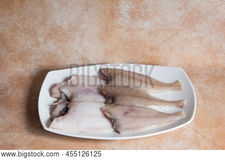 Megrim Fishes On A White Font With A Textured Abstract Studio Background. Healthy Fresh Food.