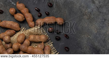 Tropical Fruits, Tamarindo Beans In Shell On A Brown Butchers Block On A Dark Background, Healthy Fr