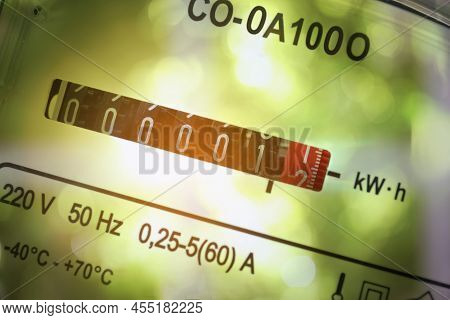 Double Exposure Of Electricity Meter And Blurred Green Background, Closeup View