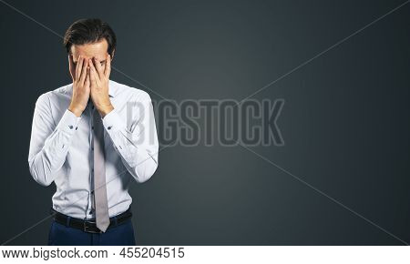 Stress And Find Solution Concept With Man In White Shirt Closing His Eyes, Facepalm Isolated On Dark