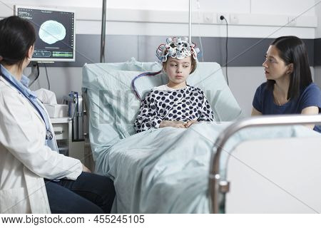 Healthcare Hospital Pediatric Medic Analyzing Eeg Scan Of Unwell Little Girl While In Pediatric Ward