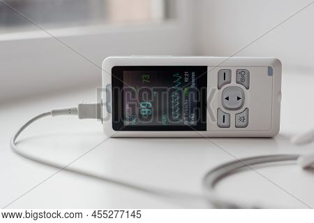 Man Using Finger Pulse Oximeter, Healthcare Monitoring Concept. Pulse Oximeter On A White Background