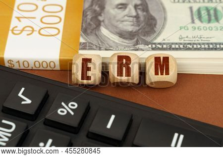 Business Concept. On The Table Are Dollars, A Calculator And Cubes With The Inscription - Erm